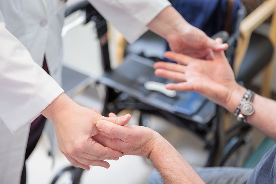 Closeup of a doctor's hands examining a patient's hands