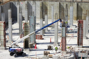 The neuroscience research building’s basement lies in a hole 25 feet deep and 400 feet long, dug at the southeast corner of Duncan and Newstead avenues. More than 106 drilled concrete piers have been poured, and the interior columns and floor in the western half of the basement have been completed. (Photo: Matt Miller/School of Medicine)