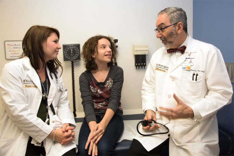 David Gutmann, MD, PhD, speaks with patient Sarah Bess and Stephanie Morris, MD, at the Neurofibromatosis Center at Washington University School of Medicine in St. Louis. Gutmann has received a grant to study the roots of the diversity of symptoms experienced by people with the genetic disorder. (Photo: Robert Boston/School of Medicine)