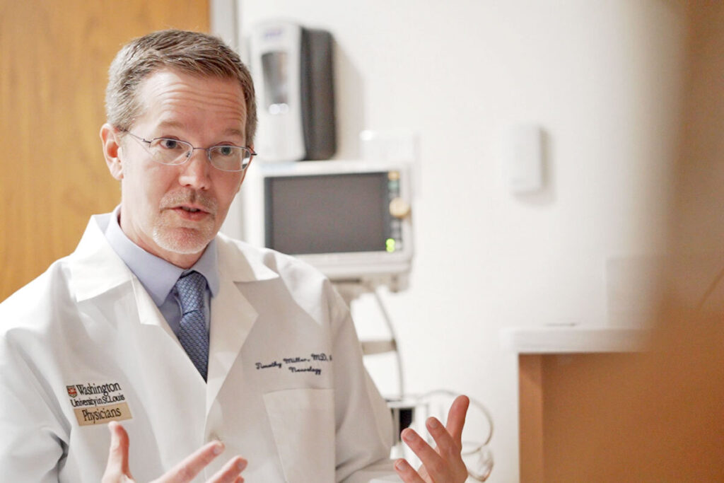 Timothy Miller, MD, PhD, talks with an amyotrophic lateral sclerosis (ALS) patient at Washington University School of Medicine in St. Louis. Miller led an international phase 3 clinical trial for a rare, inherited form of ALS. The trial, sponsored by the pharmaceutical company Biogen, showed that an investigational drug, known as tofersen, reduced molecular signs of the fatal disease, but at six months did not improve motor control and muscle strength. However, Miller and colleagues found evidence that longer-term use of the drug may help stabilize muscle strength and control.