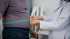 Doctor measuring patient's waistline