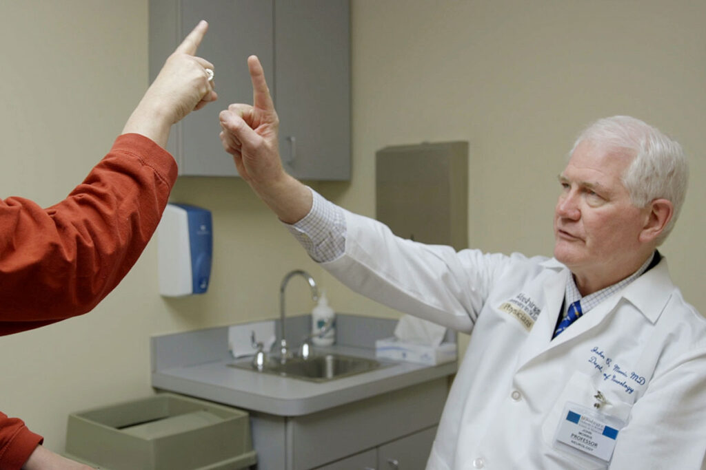 John C. Morris, MD (right), director of the Charles F. and Joanne Knight Alzheimer's Disease Research Center at Washington University School of Medicine in St. Louis, examines a patient at the center. A long-term study of adult children of Alzheimer’s patients – led by the School of Medicine – aims to define who is likely to develop the disease and when, and to establish a timeline for how quickly the disease will progress.
