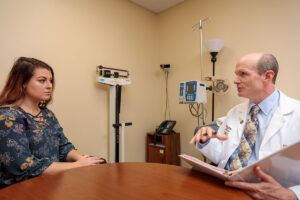 Randall Bateman, MD, director of the Dominantly Inherited Alzheimer Network-Trials Unit (DIAN-TU), an ongoing international clinical trial to evaluate experimental Alzheimer’s drugs, speaks with DIAN-TU participant Taylor Hutton. One of the drugs tested in the DIAN-TU, gantenerumab, improved biomarkers of disease despite unclear cognitive effects, prompting study leaders to offer participants the option of continuing to receive the drug and participate in follow-up examinations as part of a so-called open label extension.