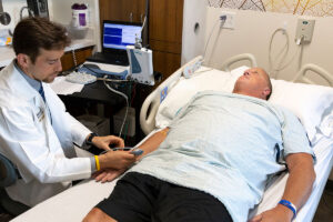 Robert Bucelli, MD, PhD, measures Gregory Easter's neuromuscular function. Easter, who has an inherited form of amytrophic lateral sclerosis, a fatal neuromuscular disease, is taking part in a clinical trial to evaluate an experimental drug. New research at Washington University School of Medicine in St. Louis shows the drug extends survival and reverses some neuromuscular damage in mice and rats and may help people whose disease is caused by mutations in the gene SOD1.