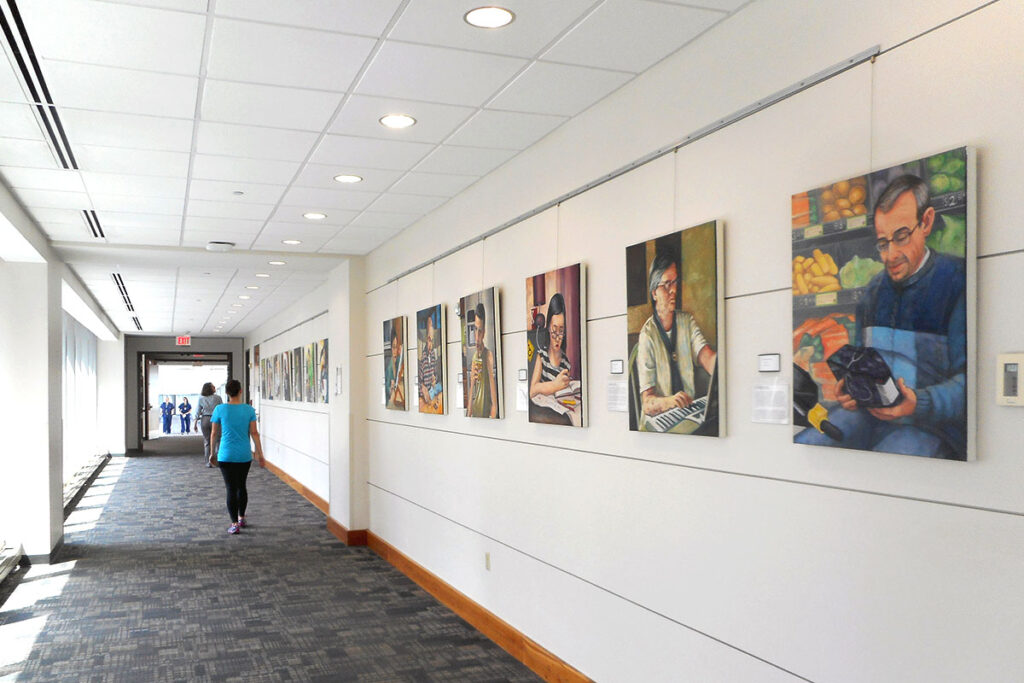 Portraits of people with neurofibromatosis, a genetic disease that causes tumors, line the hallways of the Farrell Learning and Teaching Center on the Medical Campus as part of an art installation by Rachel Mindrup titled "Many Faces of NF."