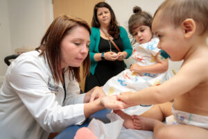 Stephanie Morris, MD, examines Henry Shrinivas, 1. Both Henry and his sister Sophie, 2, have been diagnosed with neurofibromatosis (NF1), a common genetic syndrome. A new study shows that children with NF1 are much more likely to have brain tumors than previously thought.