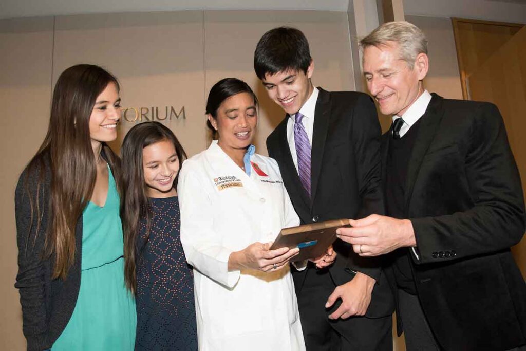 Lisa Moscoso, MD, PhD, associate dean for student affairs, shows her family the Samuel R. Goldstein Leadership Award in Medical Student Education that she received Feb. 15 at the Distinguished Faculty Awards ceremony on the Medical Campus. Shown are (from left) Moscoso's daughters Annalise and Lizzie Wagner; Moscoso; her son, John Harry Wagner; and her husband, Tom Wagner, PhD.