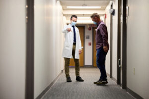 Neurologist Eric McDade, DO, meets with Marty Reiswig, a participant in Alzheimer’s prevention trials at Washington University School of Medicine in St. Louis. Reiswig comes from a family with a genetic mutation that puts carriers at high risk of developing Alzheimer’s. McDade is the director of a new Alzheimer’s prevention trial involving young adults from high-risk families. The trial is evaluating whether an investigational drug can clear a key Alzheimer’s protein called amyloid beta and slow or stop the disease. (Photo: Matt Miller/School of Medicine)