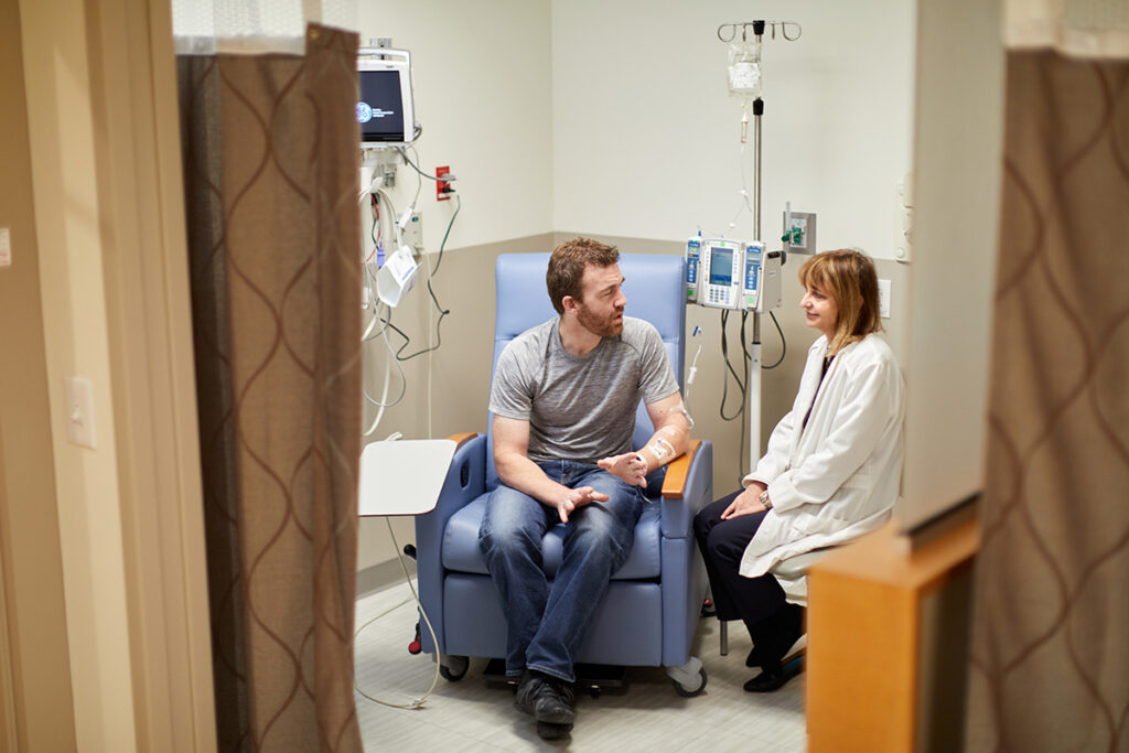Anne Cross, MD, talks with a patient getting his rituximab treatment for his multiple sclerosis (MS) at the Center for Advanced Medicine on November 1, 2019